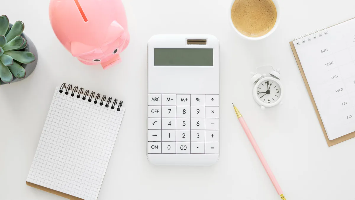Calculatrice, calendrier, horloge et tirelire représentant la planification du coût et de l'horaire d'un déménagement