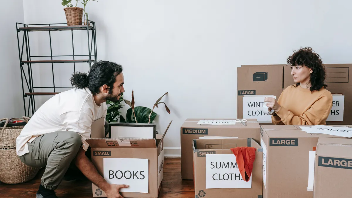 Couple sorting and labelling boxes for an organized last-minute move