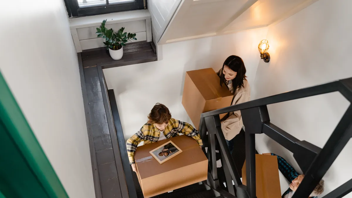 Family carrying moving boxes upstairs during a short-notice move