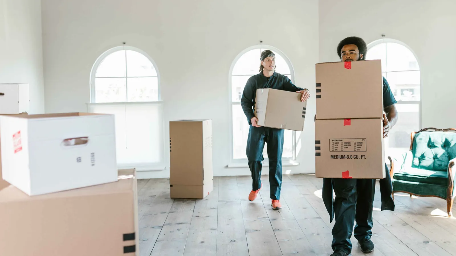 Professional movers carrying boxes during a last-minute move