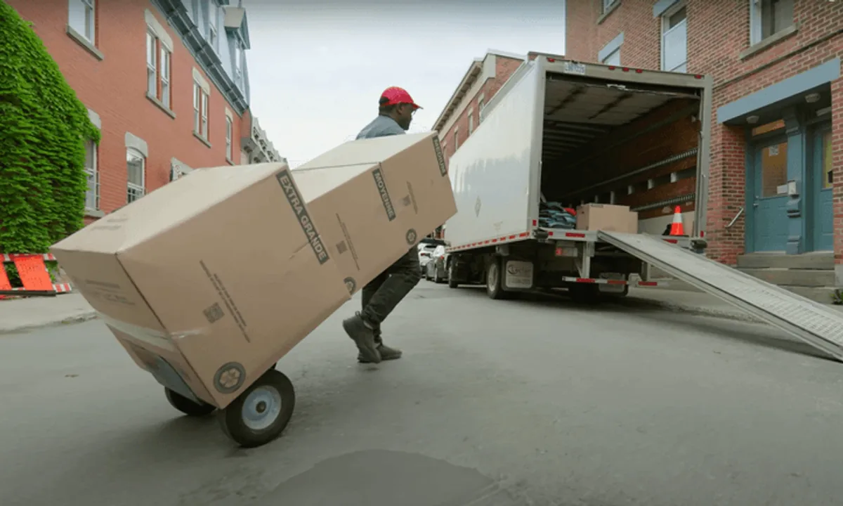Professional mover loading boxes into a truck in a Canadian neighborhood
